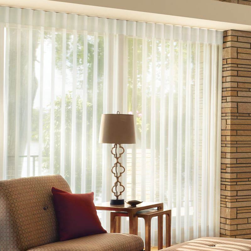 White window shades with light grey couch and blue and white pillows